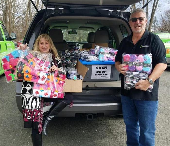 Karen and Brian holding sock donations.